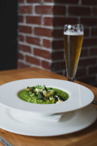 Broccoli risotto accompanied by roasted broccoli and beer cheese mornay, with Kentucky Kolsch
